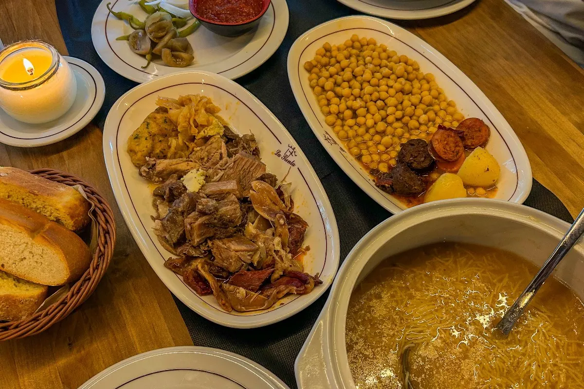 Mesa con cocido madrileño servido en sus tres vuelcos en La Tienta